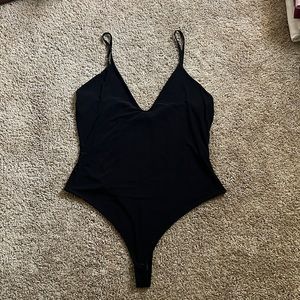 Black tank top thong bodysuit. Two buttons clasp to close.